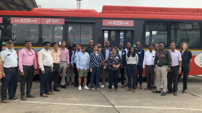 UrbanShift 孟买零排放公交车前的点对点交流参与者