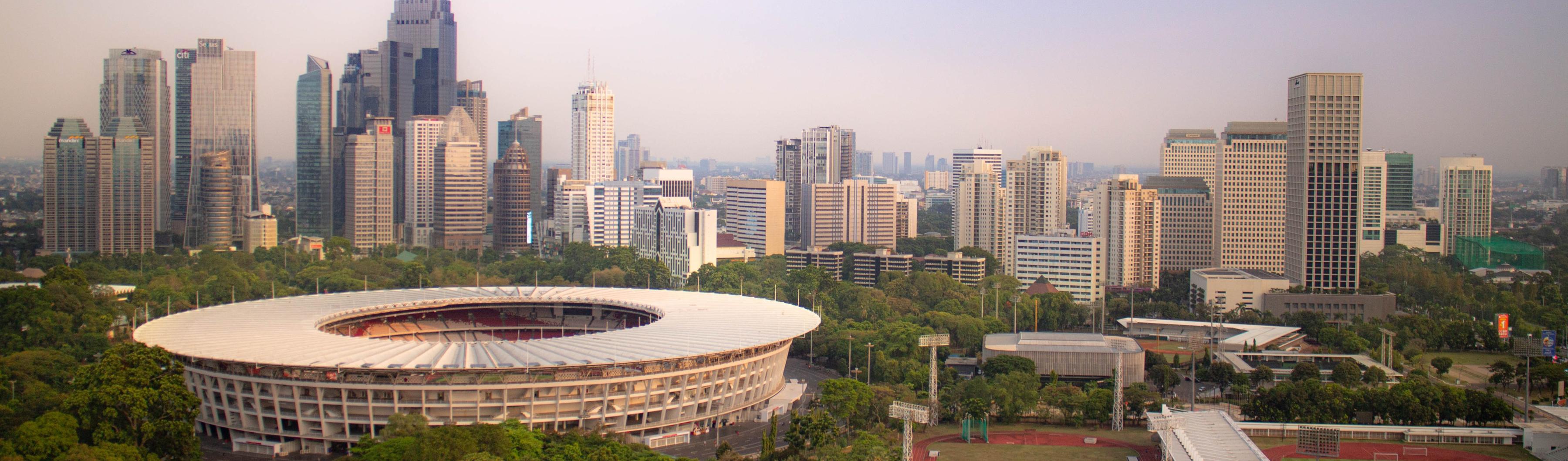 雅加达 Gelora Bung Karno 体育场的景色，周围是树木和城市天际线
